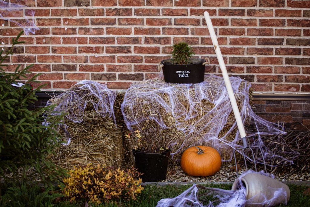 outside of a haunted house covered in fake cobwebs, a pumpkin, and other spooky decor for fall fundraising ideas