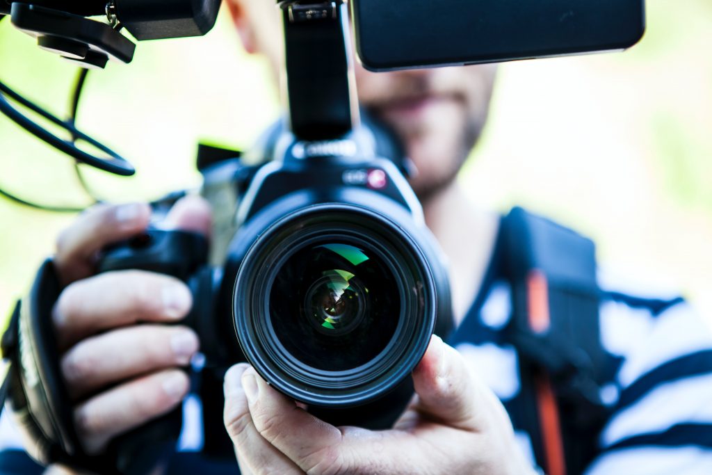 A man shooting video on a DSLR camera.