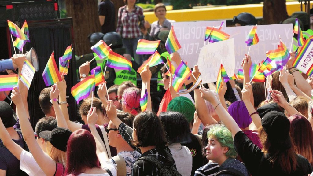 Group of supporters at a pride month event waving rainbow flags